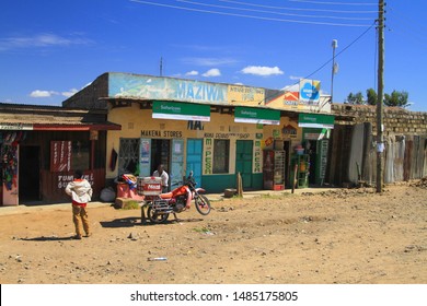 Village Street, Kenya, East Africa. February 2019. Local People Outside Small Shops With Motorcycle Used For Meat Transportation. 