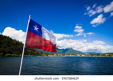 Villarrica lake, Chile in the summer. It is possible to see the lake, the flag of Chile. Sunny day, mountains in the background. Latin America, South America. Volcano, travel.