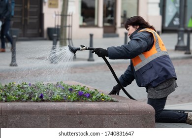 Vilnius, Lithuania - April 11, 2019: Woman City Improvement Worker Sprinkles Water On The Flowers In The Spring.