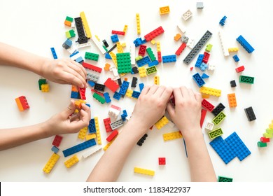 Vilnius, Lithuania - April, 2017. Children hands play with colorful lego blocks on white table.