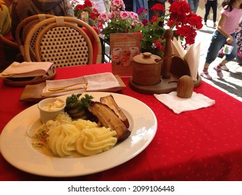 VILNIUS, LITHUANIA - AUGUST 1 2013: The Table Setting At Forto Dvaras Restaurant On Pilies Street, With A Plate Of Pork, Whipped Potatoes, Cole Slaw And Pickels.