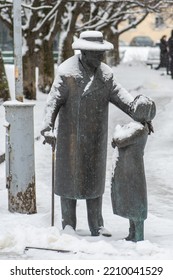 Vilnius, Lithuania - February 16 2022: Zemach Shabad Bronze Statue Taking Care Of A Girl And Her Kitty, Doctor And Vilnius Society Figure Of The First Half Of The 20th Century Covered By The Snow