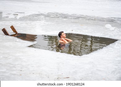 Vilnius, Lithuania - January 24 2021: Boy Or Man Bathing And Swimming In The Cold Water Of A Lake Or River, Cold Therapy, Ice Swim