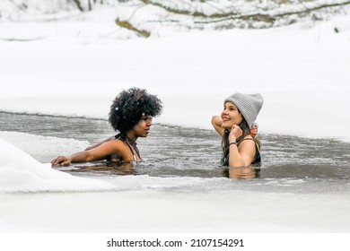 Vilnius, Lithuania - January 31 2021: Couple Of Beautiful Girls Enjoying Winter And Swimming In The Cold Water Of A Lake Or River, Cold Therapy, Ice Swim With White Winter Landscape