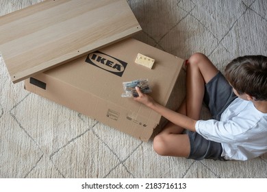 Vilnius, Lithuania - July 7, 2022: Teenage Boy Assemble Ikea Furniture At Home. IKEA Is Swedish-founded, World's Largest Furniture Retailer