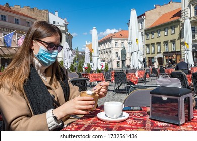 Vilnius, Lithuania - May 15 2020: Girl Having Breakfast At An Outdoor Bar, Café Or Restaurant During Covid Or Coronavirus, Masks Mandatory