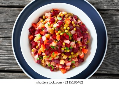 Vinegret, Russian Vinaigrette, Salad Of Diced Cooked Vegetables Red Beets, Potatoes, Carrots, Chopped Onions, Brined Pickles, Green Peas In A White Bowl On A Rustic Wooden Table, Flat Lay, Close-up