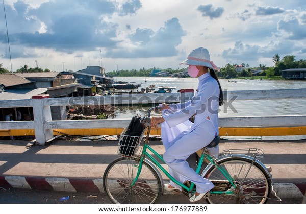 VINH\
LONG, VIETNAM - MARCH 7: School girl in white school dress bikes\
home on March 7, 2009 in Vinh Long. Education in Vietnam is divided\
into five levels from preschool to higher\
education.