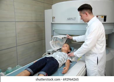 VINNITSA, UKRAINE, JULY 27, 2017: CT scanner with patient and doctor. A child before a medical procedure in a ct-scanner. Doctors examine the child on a tomograph.