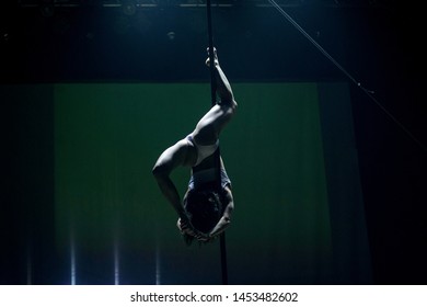 VINNITSA, UKRAINE - May 28, 2019: Young Slim Woman Pole Dancing In Dark Interior With Lights