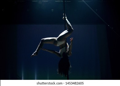 VINNITSA, UKRAINE - May 28, 2019: Young Slim Woman Pole Dancing In Dark Interior With Lights