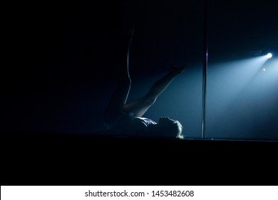 VINNITSA, UKRAINE - May 28, 2019: Young Slim Woman Pole Dancing In Dark Interior With Lights