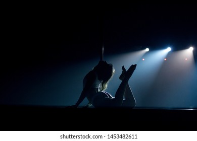 VINNITSA, UKRAINE - May 28, 2019: Young Slim Woman Pole Dancing In Dark Interior With Lights