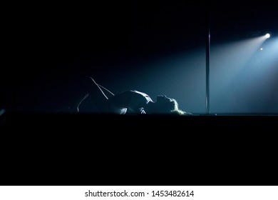 VINNITSA, UKRAINE - May 28, 2019: Young Slim Woman Pole Dancing In Dark Interior With Lights