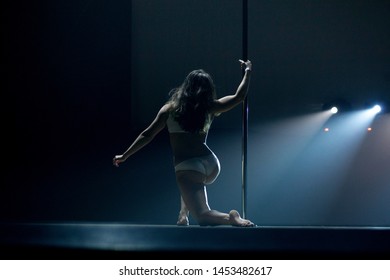 VINNITSA, UKRAINE - May 28, 2019: Young Slim Woman Pole Dancing In Dark Interior With Lights