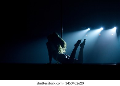 VINNITSA, UKRAINE - May 28, 2019: Young Slim Woman Pole Dancing In Dark Interior With Lights