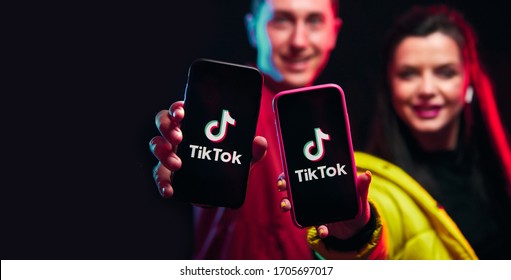 Vinnitsa,Ukraine - April 08, 2020. Tik Tok Advertisement Concept. Young Girl And Boy (blogger) Posing With Smart Phone And Making Video Content. TIK TOK Is A Popular Social Network On The Internet