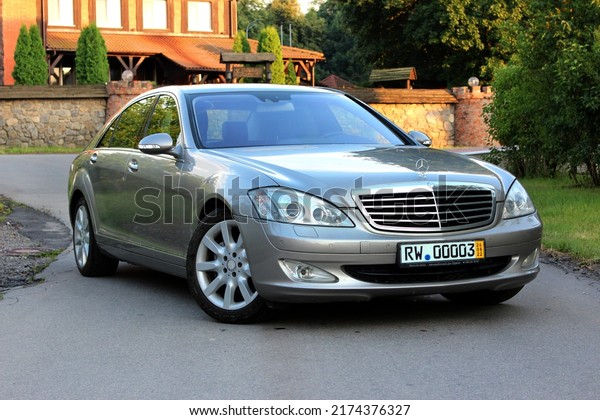 Vinnytsia, Ukraine; July 03, 2022. Grey\
Mercedes-Benz S550 Long in front of the castle. German full-sized\
luxury sedan Mercedes S-Class W221 at the city street on the\
background of green\
trees.
