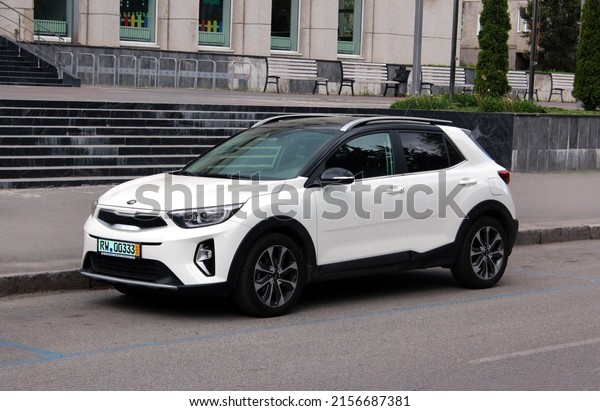 Vinnytsia, Ukraine; May 14, 2022. New Korean car\
white KIA Stonic 2022 in the city street. Mini SUV KIA Stonic at\
the parking.
