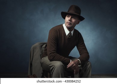 Vintage 1940 Business Man With Hat Sitting On Chair In Room.