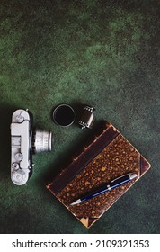 Vintage 35mm Film Camera, Old Book And Photographic Film On Green Texture Background With Copy Space