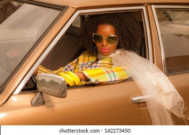 Vintage 70s Fashion Afro Woman With Sunglasses Driving In Brown Seventies Car.