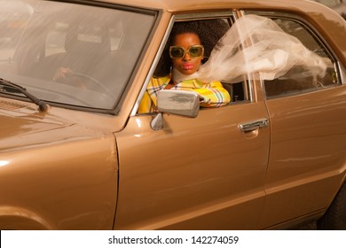 Vintage 70s Fashion Afro Woman With Sunglasses Driving In Brown Seventies Car.