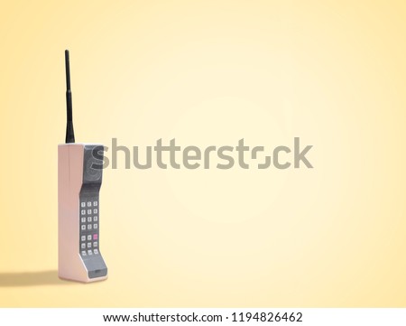 Vintage 80's Mobile Phone on yellow retro background with space for copy and text