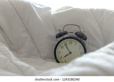 Vintage Alarm Clock Get Up On White Bed, Sheet, Duvet And Pillow In Morning With Sunny Day. Lifestyle Concept