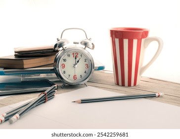 A vintage alarm clock and a striped coffee mug on a wooden desk, offering an inviting workspace for creativity, study, and relaxation. Ideal backdrop for planning and inspiration. - Powered by Shutterstock