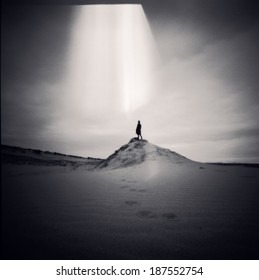 Vintage analogue pinhole photography - medium format film frame, grainy and dusty, scanned and toned - lonely figure in desert 