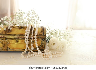 Vintage antique jewellery box and pearls necklace. Wedding concept. Back light