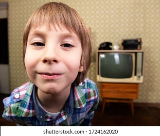 Vintage art portrait of liitle boy looking out at camera in room with interior from 70s 20th century, retro stylization. Child in flat with rarity appliances and furniture, wide angle. Stay at home