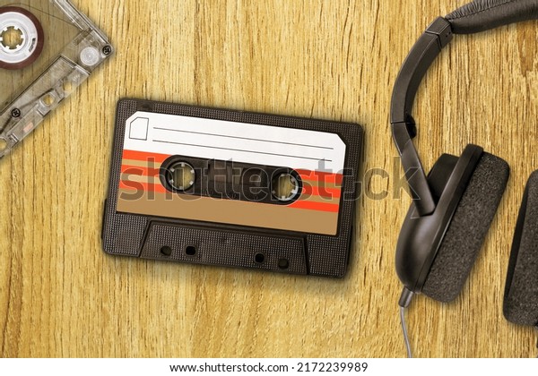 Vintage audio cassette between headphones and\
personal cassette player on a\
surface