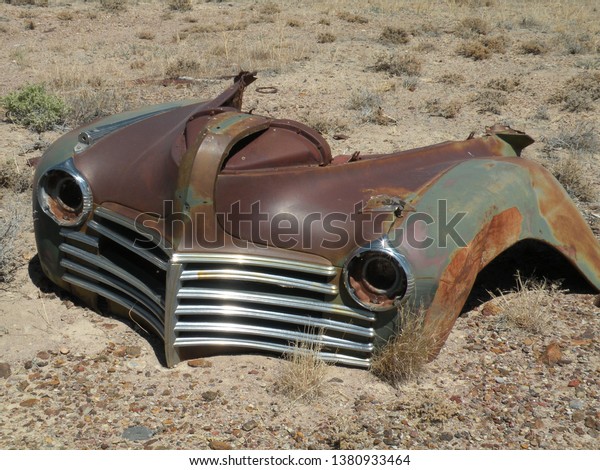 Vintage auto, rusty front end of car and grill, red,
brown and gray