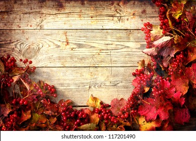 Vintage Autumn Border From Ashberry And And Fallen Leaves On Old Wooden Table/Thanksgiving Day Concept/