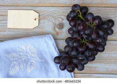 Vintage Background With A Bunch Of Fresh Organic Purple,black Grapes On A Empty Copy Space Background With A Blank Label Tag And Tea Towel..