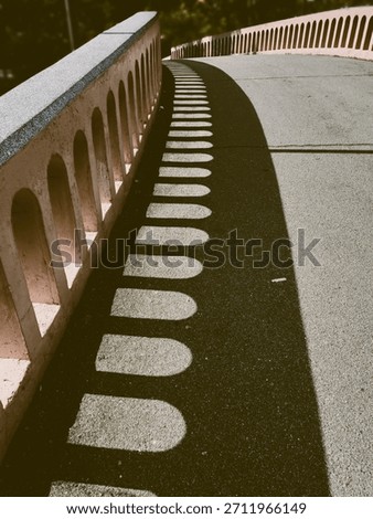 Vintage background image of light and shadow created by archways in the cement walls of the arched bridge walkway.