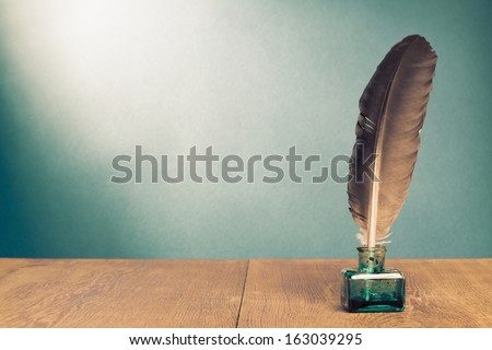 Vintage background with quill pen, inkwell on wooden table