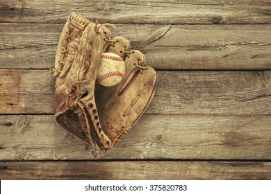 Vintage Baseball Mitt And Ball On Grungy, Rough Wood Background Viewed From Above