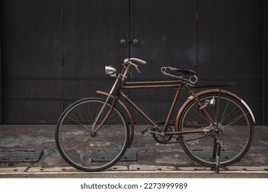 Vintage bicycle on old rustic dirty wall house, many stain on wood wall. Classic bike old bicycle on decay brick wall retro style. Cement loft partition and window background. - Powered by Shutterstock