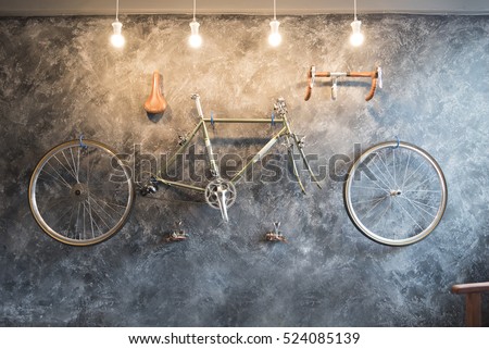 Vintage Bicycle on the wall decorate with bike cycle wheel in living room.Interior Design with people lifestyle hobby in a modern city. Bicycle with bulb lighting as background and loft decorate style