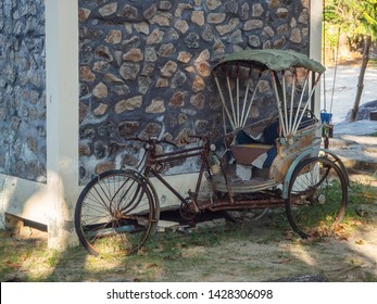 Vintage Bicycle With A Sidecar Stands At The Wall Of The House