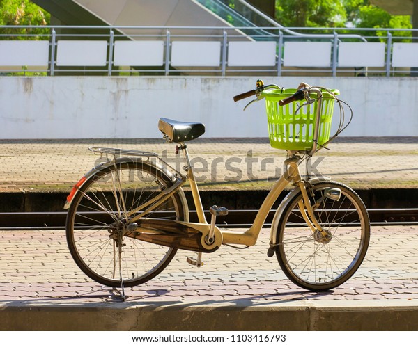 Vintage\
bicycle with train station a basket\
mornimg