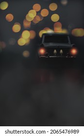 A Vintage Black Car In A Dark Foggy Road With Blurred Street Lights