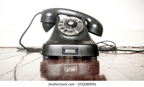 vintage black phone on a old wooden floor