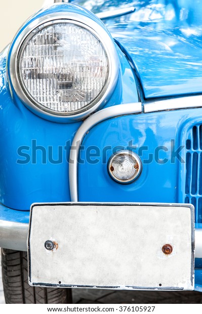 Vintage\
blue car,head light and licensed plate close\
up.
