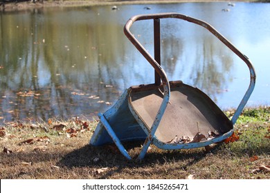 The Vintage Blue Metal Lawn Chair Has Been Forgotten At The Ponds Edge