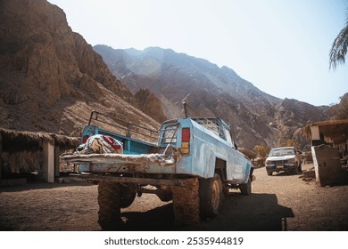 Vintage Blue Pickup Truck in Desert Landscape Surrounded by Mountains - Powered by Shutterstock