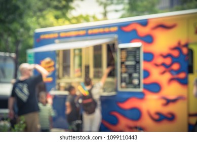 Vintage Blurred Motion Food Truck Vendor Customers Buy And Taste Variety Of Foods. Customer Waiting, Queuing In Line To Pick Up Food And Drink Delivery At Urban Park In Dallas, Texas, USA.